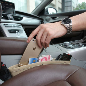 Person placing an iPhone into a car console organizer with various items.