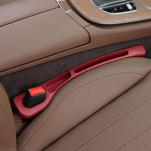 Car interior with a red door handle and brown leather seats.
