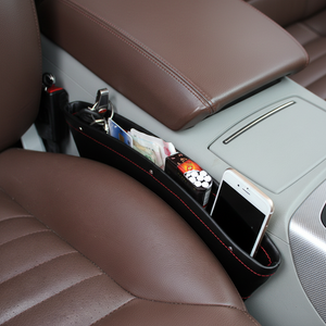 Car organizer with phone, keys, and cards inside a car.