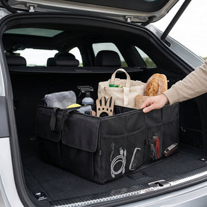 Car trunk with a black organizer holding various items, including a bag and bread.
