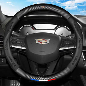 Steering wheel with Cadillac logo and carbon fiber texture against a blue sky background