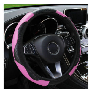 Steering wheel cover with pink and black design on a car steering wheel