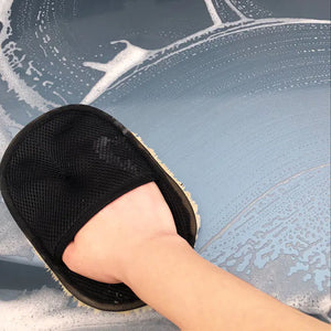 Person wearing a black slipper on a car's windshield with soapy water.