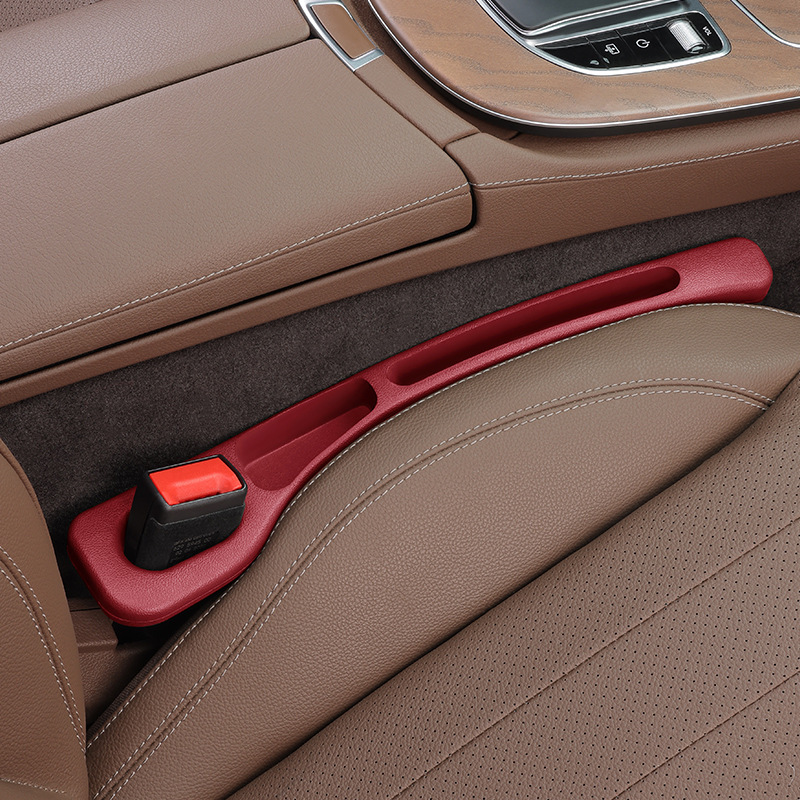 Car interior with a red door handle and brown leather seats.