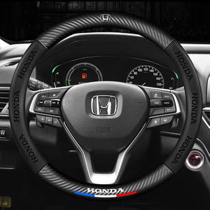 Steering wheel with Honda logo and carbon fiber texture in a car interior.