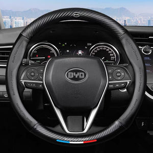 Steering wheel with BYD logo in a car interior, featuring the brand's slogan.