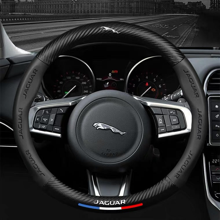 Steering wheel of a Jaguar car with visible brand logo and dashboard.