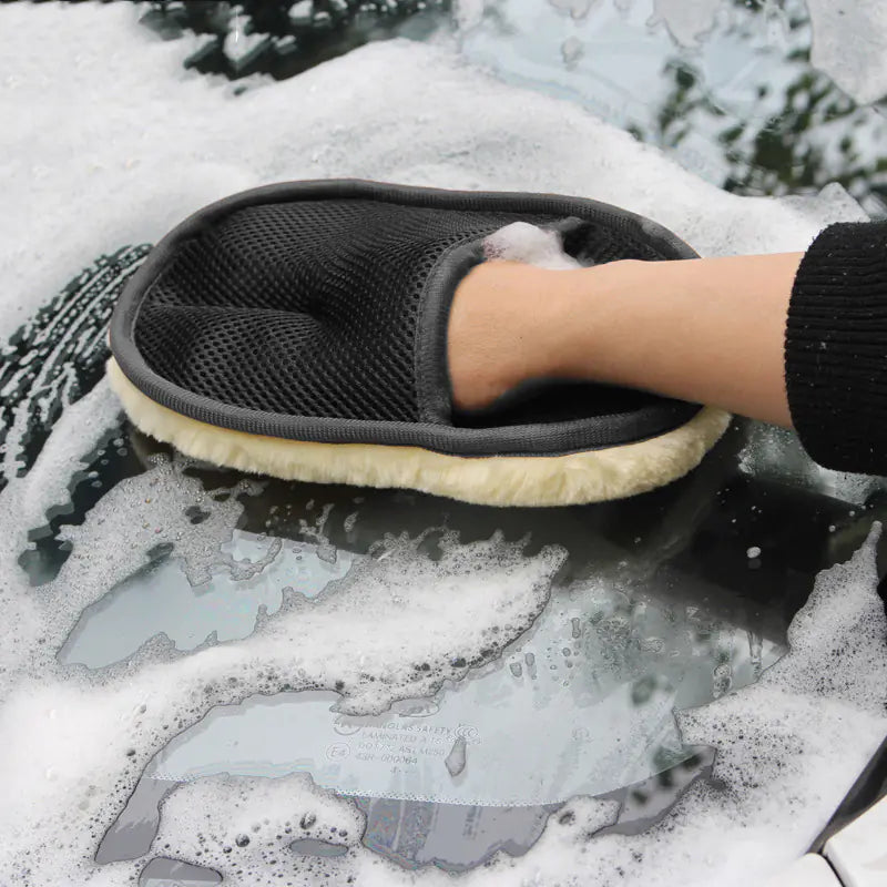 Person cleaning a car window with a soapy sponge