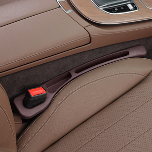 Close-up of a car's brown leather interior with a cup holder.