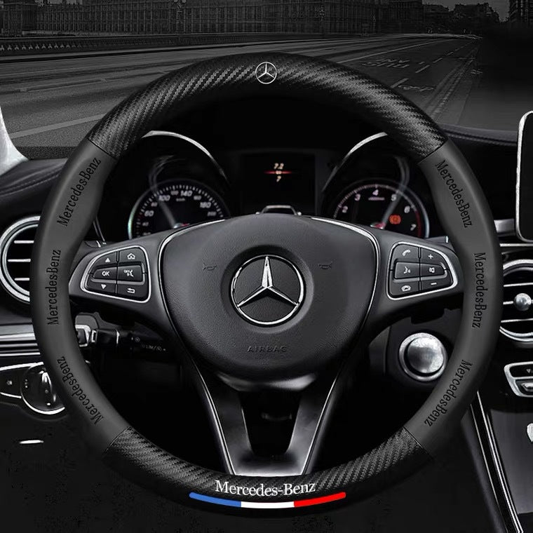 Steering wheel of a Mercedes-Benz car with logo and branding.