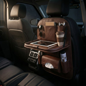 Car back seat organizer with tablet, cup, and other items in a vehicle interior.