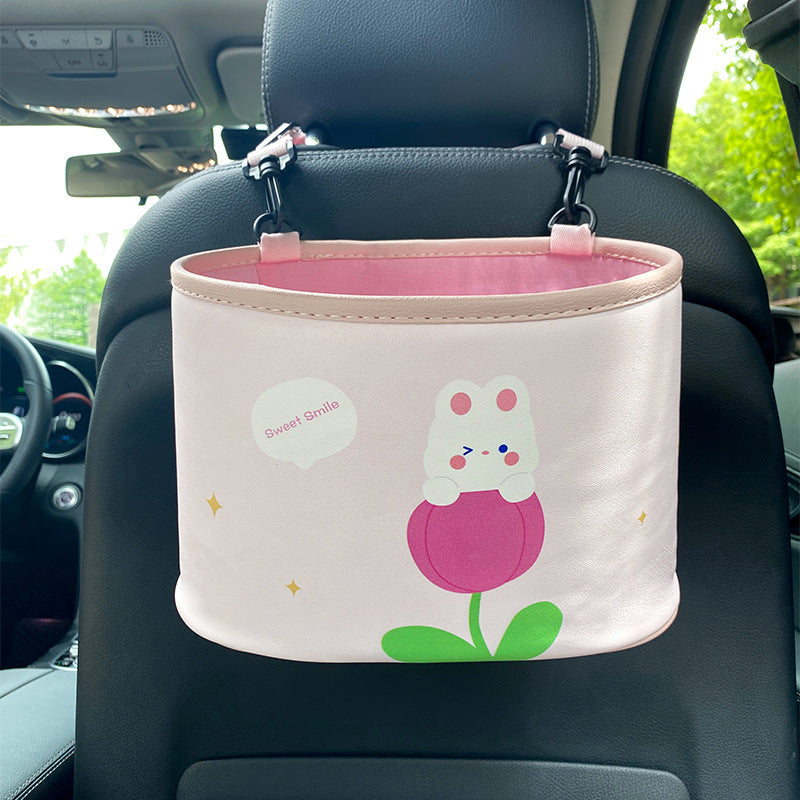 Pink car organizer with cartoon design attached to a car seat