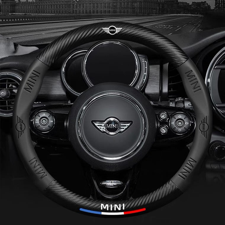 Steering wheel of a Mini car with the brand logo prominently displayed.